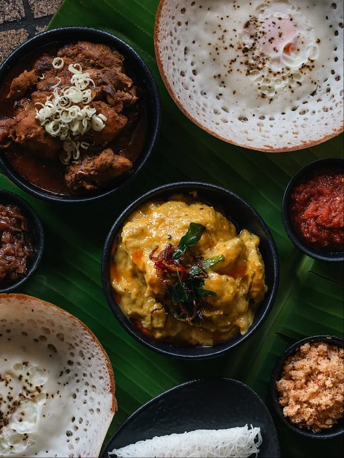 Overhead shot of a Sri Lankan food spread with curries, rice, and condiments